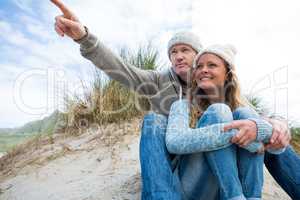 Happy mature couple pointing at view