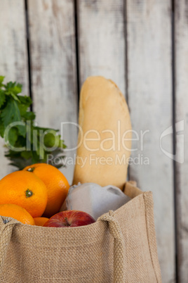 Fruits and vegetables with bread loaf in grocery bag