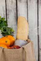 Fruits and vegetables with bread loaf in grocery bag