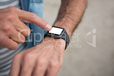 Mid section of man wearing smartwatch on beach