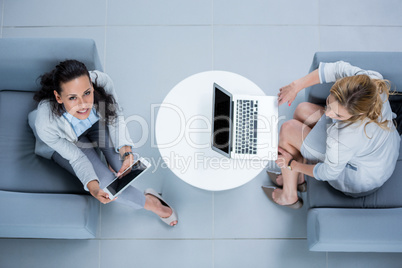 Businesswomen using laptop and digital tablet