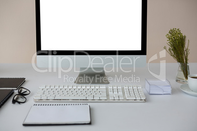Desktop pc with coffee and diary on table
