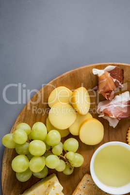 Variety of cheese with grapes, meat and crackers