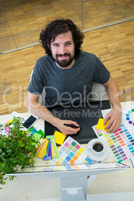 Graphic designer working on graphic tablet at his desk