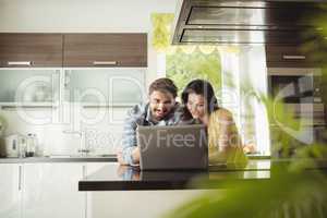 Happy couple using laptop