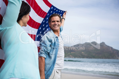 Couple holding american flag on beach