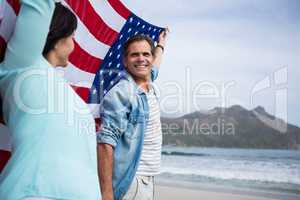 Couple holding american flag on beach