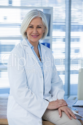 Portrait of a smiling female doctor sitting at desk