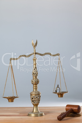 Conceptual image of watch and coins on the justice scale