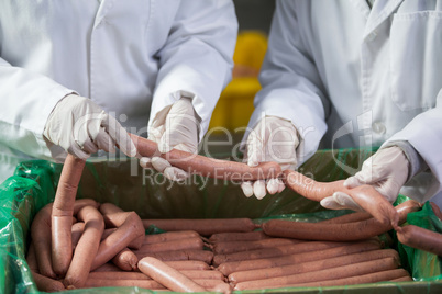 Butchers processing sausages