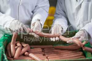 Butchers processing sausages