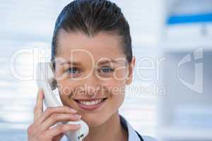 Smiling female doctor talking on telephone