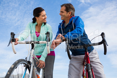 Couple leaning on bicycle while interacting with each other