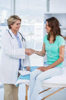 Female doctor shaking hands with patient