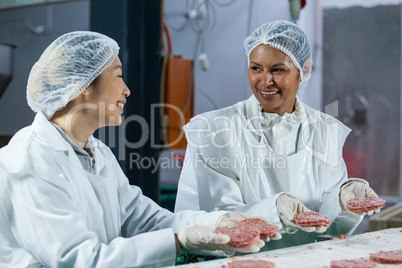Female butchers processing hamburger patty