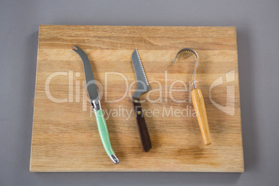 Cheese cutting tools on wooden board