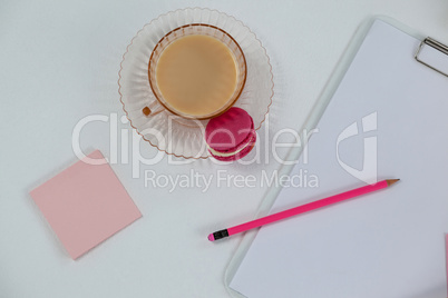 Cup of tea with macaroon, clipboard, pencil and sticky note