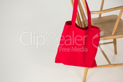 Red bag hanging on a wooden chair