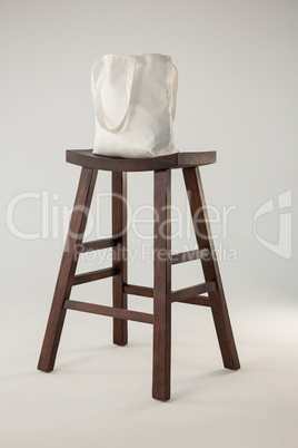 White bag on wooden stool