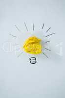 Light bulb drawn around crumbled yellow paper