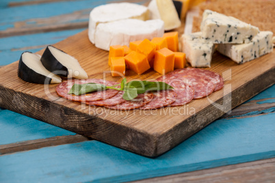 Ham with various cheese on chopping board