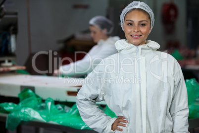 Female butcher standing with hands on hip
