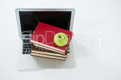Laptop, stack of books and apple on white background
