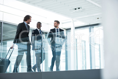 Businessman talking with colleagues while walking