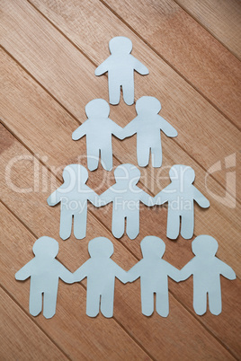 Paper cut outs forming human pyramid