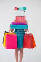 Woman carrying stack of gift boxes and shopping bags