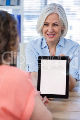 Doctor discussing with patient over digital tablet at the hospital