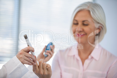 Doctor checking glucose level in diabetic patient