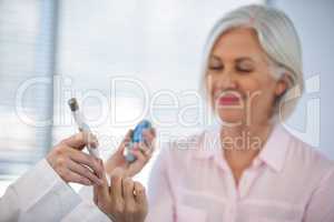 Doctor checking glucose level in diabetic patient