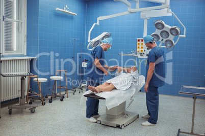 Surgeons interacting with patient during operation