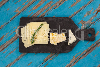 Cheese with rosemary on chopping board