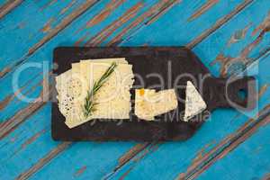 Cheese with rosemary on chopping board