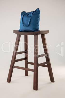 Blue bag on wooden stool