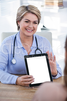 Doctor showing digital tablet to patient