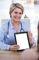 Doctor showing digital tablet to patient