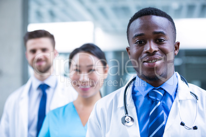 Confident doctor standing with colleagues