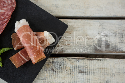 Salami and sliced meat on slate board