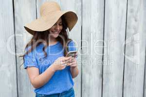 Beautiful woman in blue top and hat using mobile phone