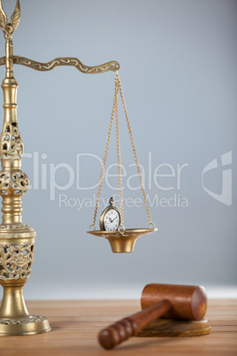 Conceptual image of pocket watch on justice scale