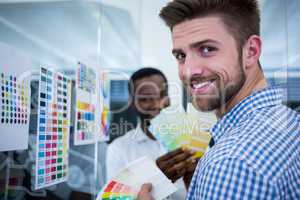 Graphic designers holding color swatch