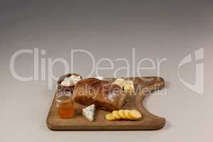 Variety of cheese with bread and sauce on chopping board