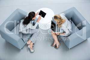 Businesswomen discussing over digital tablet