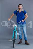 Man in blue t-shirt and backpack with a bicycle