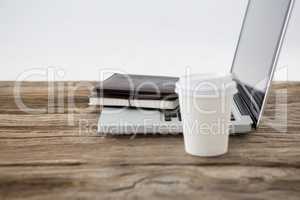 Laptop with diary and disposable coffee cup