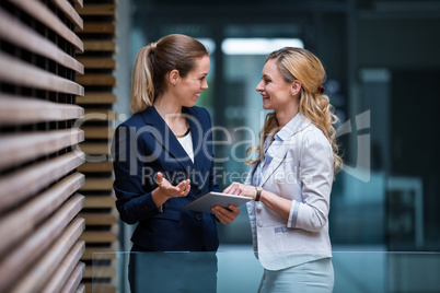 Business colleagues discussing over digital tablet