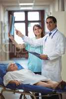 Doctor and nurse examining report in corridor